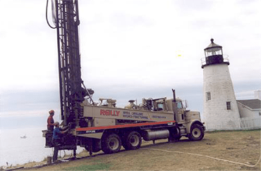 Reilly Well Drilling truck near a lighthouse in Midcoast Maine